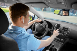 Man driving car and using GPS on smartphone. Riverside Commercial vehicle accidente lawyers