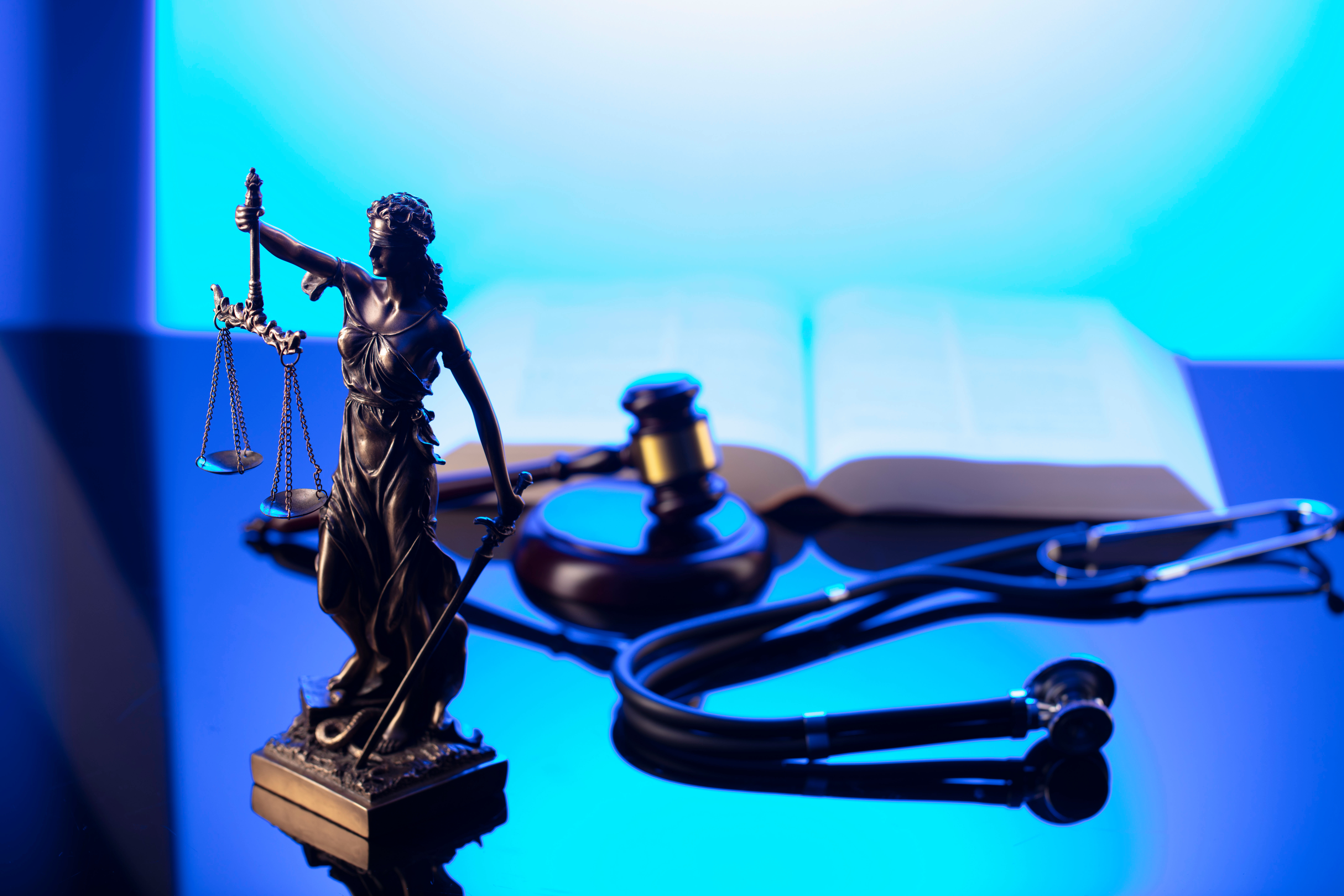 Filing a Medical Malpractice Claim in Ontario, CA 1 Medical malpractice law concept. Gavel, Themis, legal code and stethoscope on the glass table. Blue light.