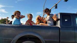 Family riding in the bed of a pickup truck