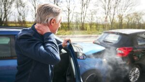 hombre mirando el coche después de un accidente de coche. culpa en un accidente de coche en California