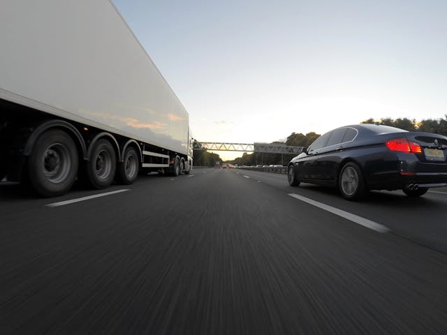 truck and a car driving on a highway - Stockton Truck Accident Lawyers