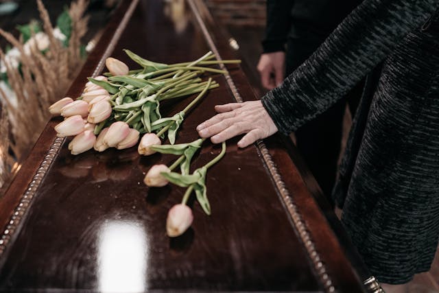 woman holding hand on a coffin - Riverside Wrongful Death Lawyers
