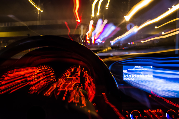 Night dashboard blur with police lights ahead, illustrating legal risks of drinking non-alcoholic beer while driving.